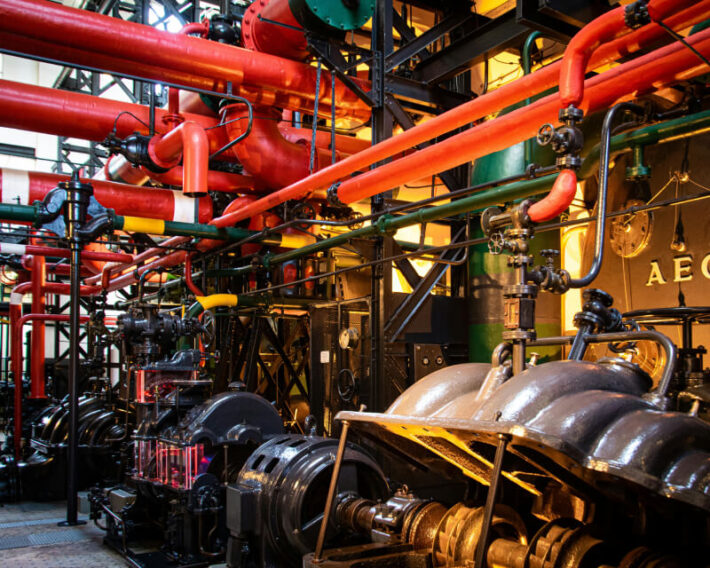 Complex manufacturing site with pipes, valves, and gears.