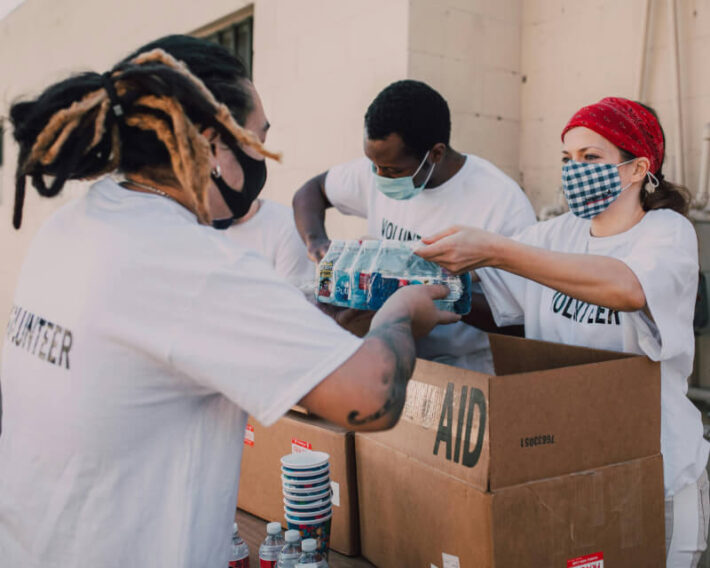 Group of three volunteers packing up aid boxes.